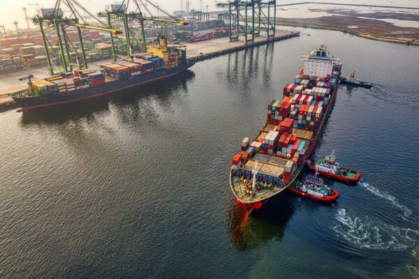 Red and blue cargo ship on water during daytime